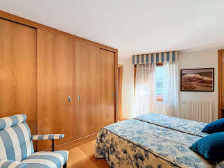 This bedroom boasts built-in wooden wardrobes with sliding doors, offering ample storage space.
