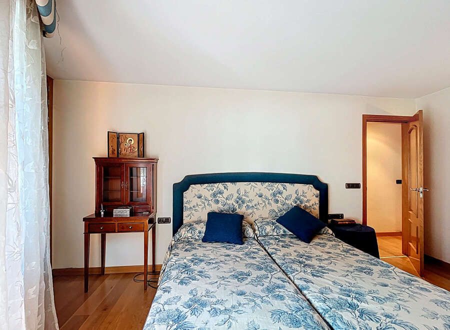 This beautiful bedroom features a comfortable double bed with a floral pattern, perfect for a relaxing night's sleep.