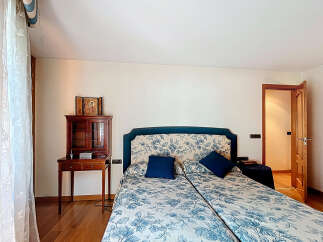 This beautiful bedroom features a comfortable double bed with a floral pattern, perfect for a relaxing night's sleep.