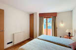 Bright bedroom with twin beds, offering stunning mountain views from its private balcony.