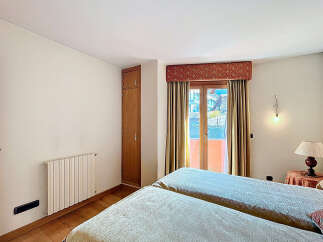 Bright bedroom with twin beds, offering stunning mountain views from its private balcony.