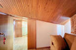 Discover this charming attic room featuring a wood paneled ceiling and ample natural light.
