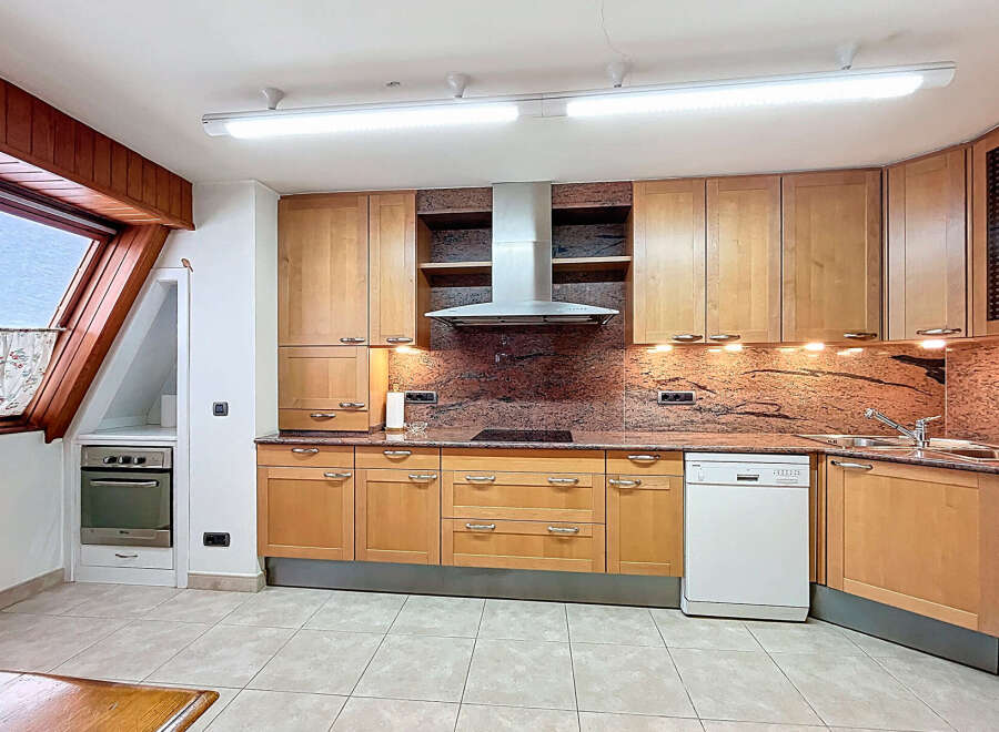 This stunning kitchen boasts a modern design with light wood cabinets and granite countertops.