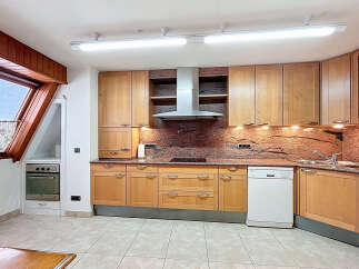 This stunning kitchen boasts a modern design with light wood cabinets and granite countertops.