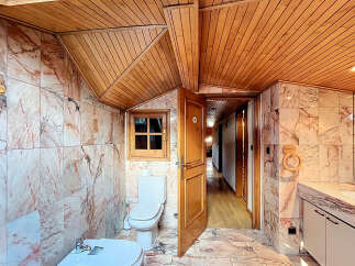 This stunning bathroom boasts a unique blend of rustic wood ceilings and elegant marble tiling, creating a luxurious and inviting atmosphere.