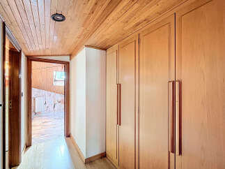 This stunning property boasts a hallway with built-in wooden wardrobes, offering ample storage space.