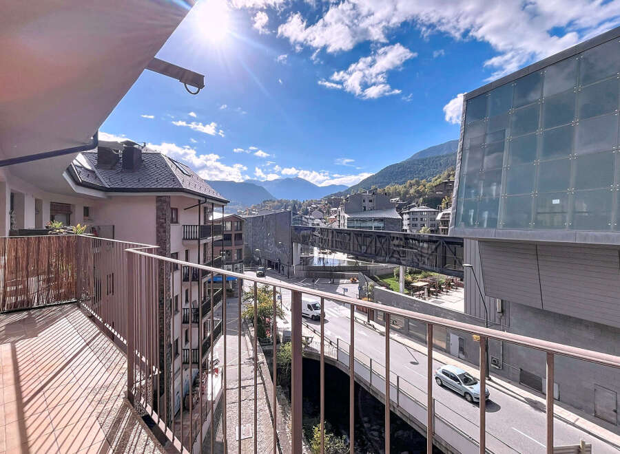 Enjoy breathtaking views from this stunning property! This modern residence features a spacious balcony overlooking a picturesque cityscape and mountains.