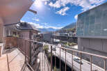 Enjoy breathtaking views from this stunning property! This modern residence features a spacious balcony overlooking a picturesque cityscape and mountains.