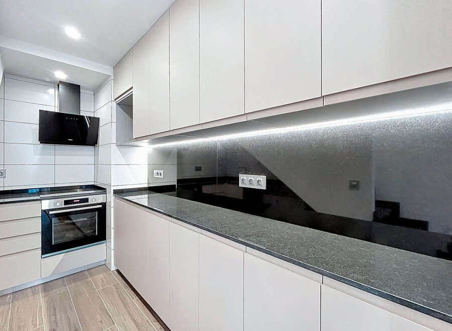 This modern kitchen features sleek, minimalist design with ample storage and counter space.