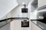 Modern kitchen design featuring sleek black countertops and white cabinetry.