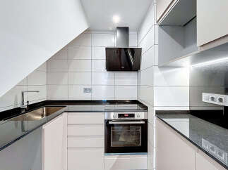 Modern kitchen design featuring sleek black countertops and white cabinetry.