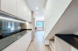This modern kitchen features sleek, minimalist design with ample storage and a stunning black countertop.