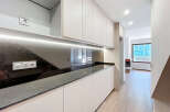 This modern kitchen boasts sleek, minimalist design with ample storage and a stunning countertop.