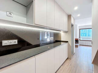 This modern kitchen boasts sleek, minimalist design with ample storage and a stunning countertop.