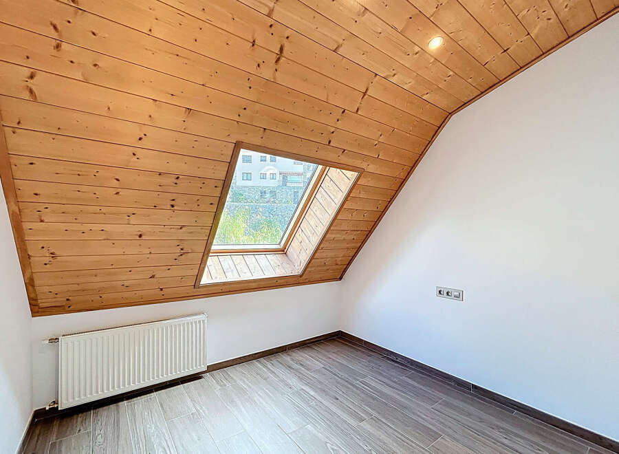 Discover the charm of this unique attic space, featuring a stunning wooden ceiling and a skylight that floods the room with natural light.