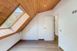 Discover the charm of this unique attic space, featuring a stunning wooden ceiling and a large skylight that floods the room with natural light.