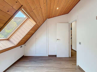 Discover the charm of this unique attic space, featuring a stunning wooden ceiling and a large skylight that floods the room with natural light.