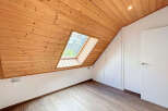 Discover the charm of this unique attic space, featuring a stunning wooden sloped ceiling and a skylight that floods the room with natural light.
