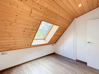 Discover the charm of this unique attic space, featuring a stunning wooden sloped ceiling and a skylight that floods the room with natural light.
