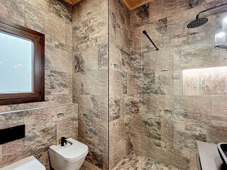 Step into luxury with this stunning bathroom featuring exquisite stone tile work.