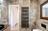 Step into a beautifully designed bathroom featuring a modern black towel warmer, adding both style and functionality.