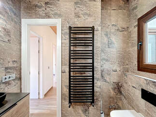 Step into a beautifully designed bathroom featuring a modern black towel warmer, adding both style and functionality.