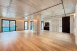 Stunning open-plan living space with exposed concrete ceilings and sleek modern finishes.