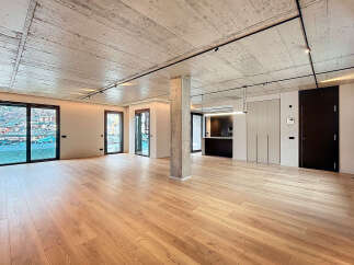 Stunning open-plan living space with exposed concrete ceilings and sleek modern finishes.