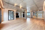 Stunning open-plan living space with exposed concrete ceilings and sleek modern finishes.