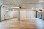Stunning open-plan living space with exposed concrete ceilings and sleek modern lighting.