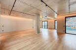 Stunning open-plan living space with exposed concrete ceilings and sleek modern lighting.