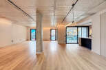Stunning open-plan living space with exposed concrete ceilings and sleek modern finishes.