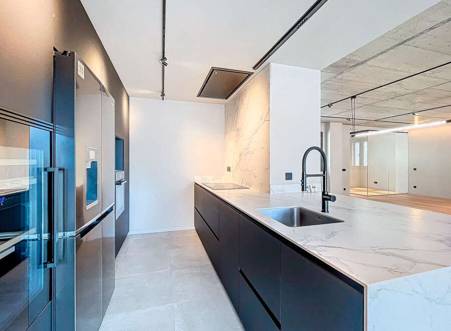 Modern kitchen with sleek black cabinetry and integrated appliances.