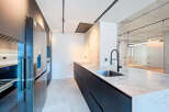 Modern kitchen with sleek black cabinetry and integrated appliances.