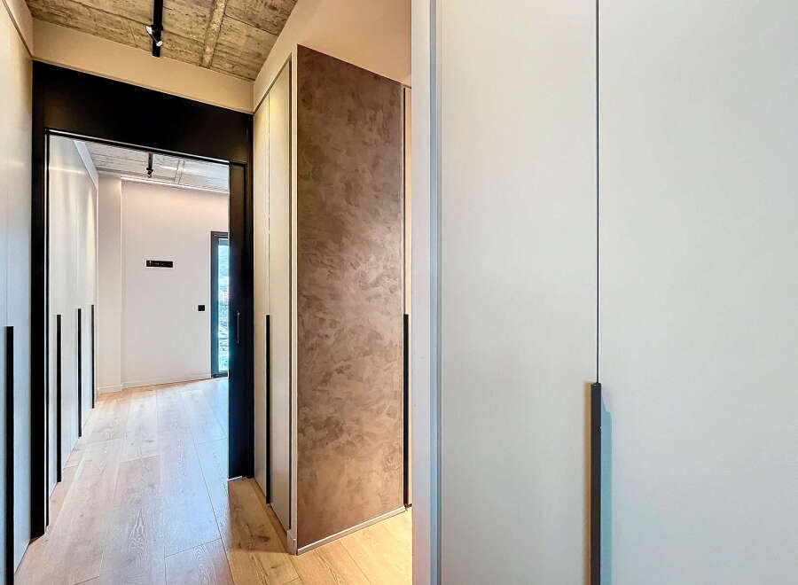 Modern hallway with built-in closets and sleek design.