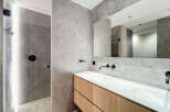Modern bathroom with double vanity and walk-in shower.