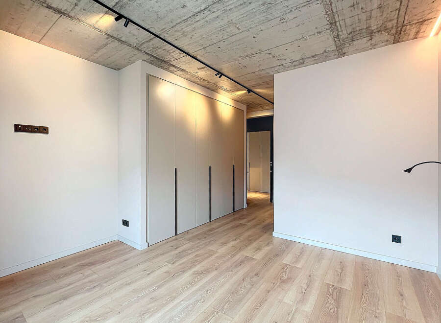 Modern apartment boasts sleek built-in wardrobes and a minimalist design.