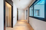 This stunning hallway boasts sleek, modern design with dark-framed doors and windows offering ample natural light.