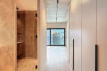 Modern apartment hallway with built-in wardrobes and a view.