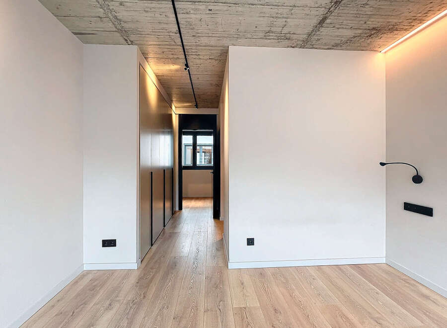 This stunning property boasts a modern, minimalist design with sleek built-in wardrobes and a light oak wood floor.