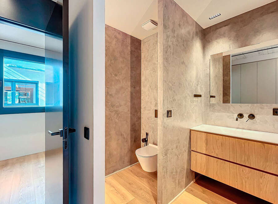 Modern bathroom with concrete walls and wooden vanity.