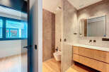 Modern bathroom with concrete walls and wooden vanity.