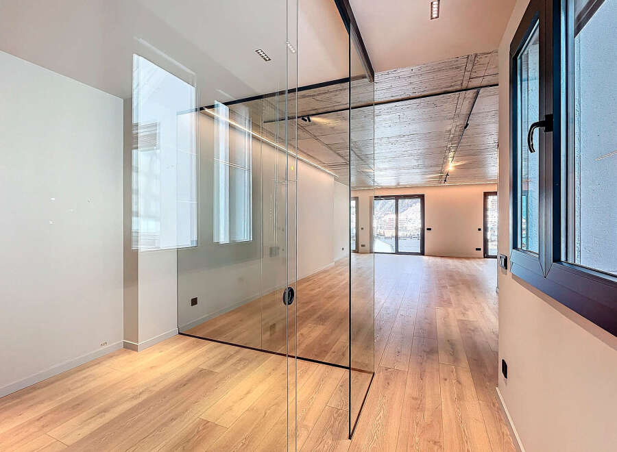 This stunning apartment boasts a sleek, modern design with glass partitions separating the living areas, creating an open and airy feel.