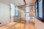This stunning apartment boasts a sleek, modern design with glass partitions separating the living areas, creating an open and airy feel.