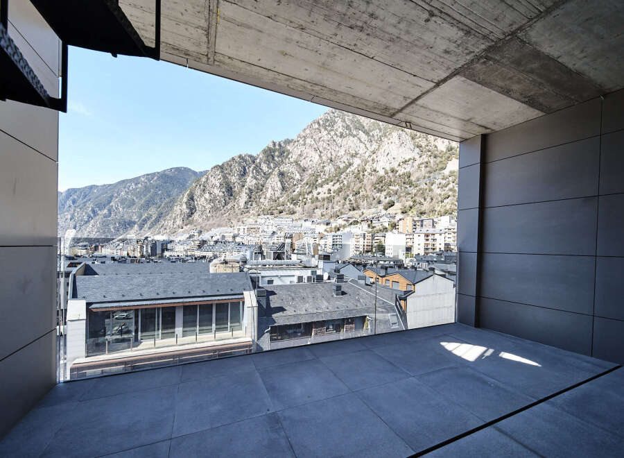 Modern apartment balcony boasting panoramic mountain and city views.