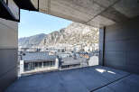 Modern apartment balcony boasting panoramic mountain and city views.