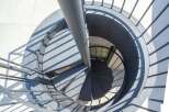 Modern spiral staircase with metal railings and diamond plate treads.