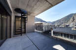 This stunning penthouse boasts a spacious balcony with breathtaking mountain views and a modern spiral staircase.