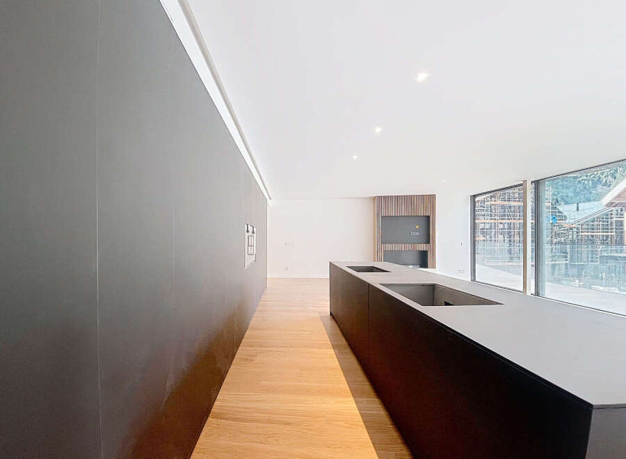 Modern kitchen with sleek dark cabinetry and integrated appliances.