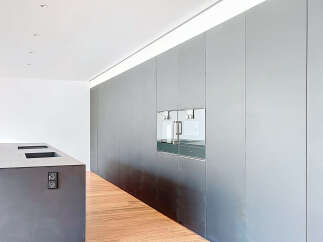 Modern kitchen with sleek, dark gray cabinetry and integrated appliances.